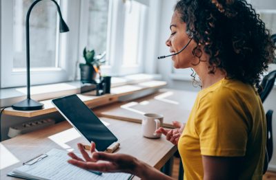 Businesswoman using tablet and headset in the office.