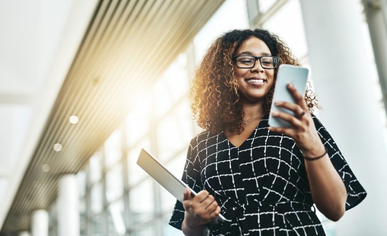 A young woman using a smartphone in a modern office