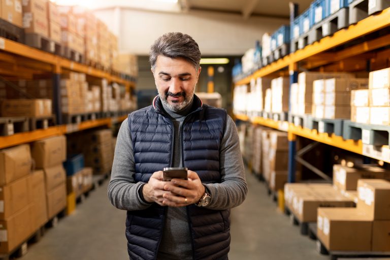 A warehouse employee with boxes at the background