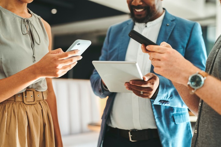 A group of employees holding a mobile device