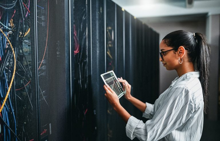 Shot of a young woman using a digital tablet while working in a server room