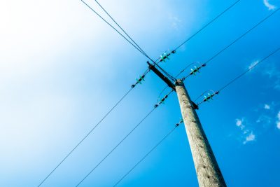 Clouds against blue sky with telegraph pole